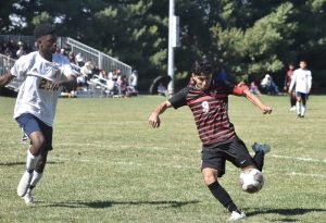 Marshall senior Derick Juarez (9) tries to put a shot on net despite the effort of Battle junior Prince Kahebwa. Juarez netted a hat trick, helping the Owls avenge the only blemish on their otherwise perfect record with a 7-2 win Saturday. Hobby King/Democrat-News