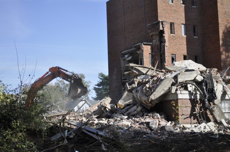 As of 10:30 a.m. Friday, Oct. 21, the front of what is commonly referred to as “the old hospital” had been razed and crews were still at work. The building on South Brunswick Avenue was the original Fitzgibbon Hospital, but has since had approximately three different owners before the city of Marshall purchased it for demolition. Neighborhood residents have been adamant for a solution to the decaying structure for several years, and it was eventually condemned. Sarah Gray/Democrat-News