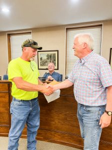 Marshall Municipal Services Director Terry Gibson (left) accepts a work recognition plaque from Marshall Mayor Vince Lutterbie (right) at the city council meeting on Tuesday, June 20. Danielle Linton-Hatfield/Democrat-News