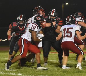 Marshall seniors Tashaun Edmund (72) and Nick Arnold (58) try to get to Chillicothe junior running back Silas Midgyett. Midgyett was held in check for the most part, and the Owls’ defense was strong in helping the Owls win the opener 19-13 last Friday. (Hobby King/Democrat-News)