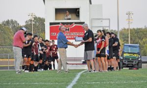 Marshall head coach Justin Van Winkle (right) is presented the award as the “Coach of the Year” for the entire state of Missouri in the sport of soccer by assistant executive director of boys’ soccer at the Missouri State High School Activities Association Marty Marsh Monday night. (Sarah Gray/Democrat-News)