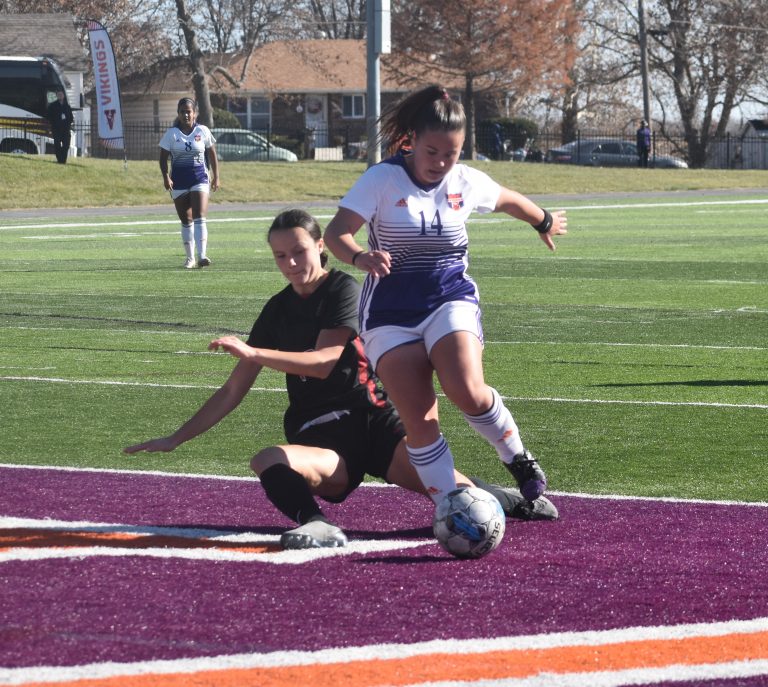 Lady Viking sophomore midfielder Carla Carmona (14) tries to make a move around a sliding tackle by a Hastings defender. (Hobby King/Democrat-News)