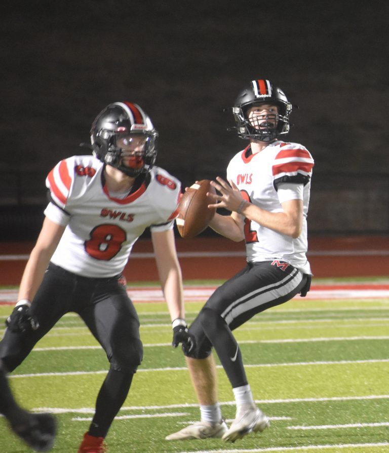 With Marshall senior Jaxson Case (8) looking for somebody to block, sophomore quarterback Chase Thompson (2) sets his feet to throw one down the field. Thompson completed 14 of 28 passes for 98 yards. (Hobby King/Democrat-News)