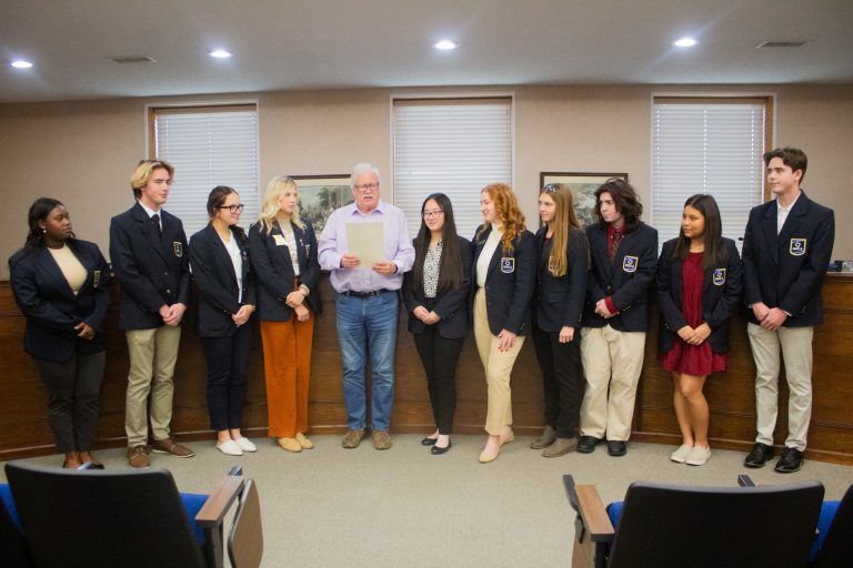 Marshall Mayor Vince Lutterbie reads a proclamation deeming November as Distributive Education Clubs of America (DECA) Month for the Saline County Career Center. DECA students gathered in the Marshall City Council Chambers on Wednesday afternoon, Nov. 1, and talked about their projects. Pictured left to right are: KiAsiah Harris; Jackson Russell; Avery Evans; Bailey Kueker; Lutterbie; Michelle Lin; Holly Huston; Peyton Marshall; Kolten Gotmer; Kaylen Alvarez; and Ethan Russell. Danielle Linton-Hatfield/Democrat-News