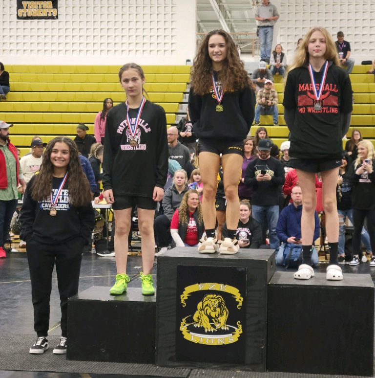 Lady Owl freshman McKenzy Mason (right) stands on the podium as the second-place finisher in the 100-pound weight class at the Fort Zumwalt East Invitational. Mason won two of her three matches and is 10-1 overall this season. (Contributed image)