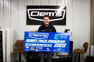 Mark Clemons, with Clem’s Sign, celebrates five years of raising funds for the Saline County Buddy Pack Program — a partnership done with The Food Bank for Central and Northeast Missouri. Last year the total funds raised was $21,030. This year’s funds came out at $21,420 and will feed 75 kids who attend schools in Saline County. Danielle Linton-Hatfield/Democrat-News