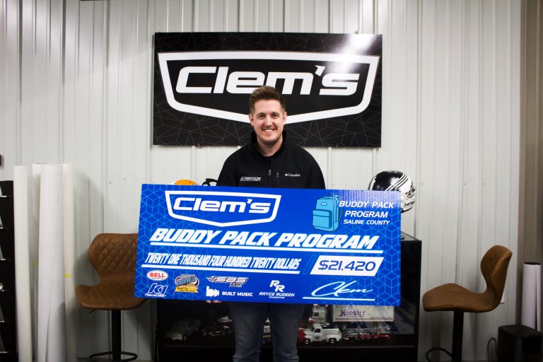 Mark Clemons, with Clem’s Sign, celebrates five years of raising funds for the Saline County Buddy Pack Program — a partnership done with The Food Bank for Central and Northeast Missouri. Last year the total funds raised was $21,030. This year’s funds came out at $21,420 and will feed 75 kids who attend schools in Saline County. Danielle Linton-Hatfield/Democrat-News
