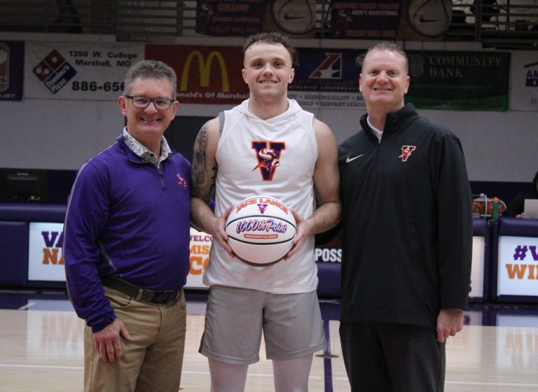 Prior to the men’s game versus Clarke, Marshall native Jace Lance (middle) received a basketball honoring him scoring his 1,000th point in a Vikings’ uniform. He was presented the ball by athletic director Mike Machholz (left) and his father and men’s basketball coach Chad Lance. (Photo courtesy MVC Athletics)