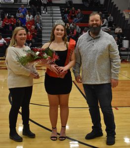 MHS senior Zoe Dryer (middle) was voted Winterwarming Queen. She was honored at halftime of the MHS boys’ versus Mexico basketball  game Monday night. Zoe’s parents are Kevin (right) and Jackie Dryer. (Hobby King/Democrat-News)
