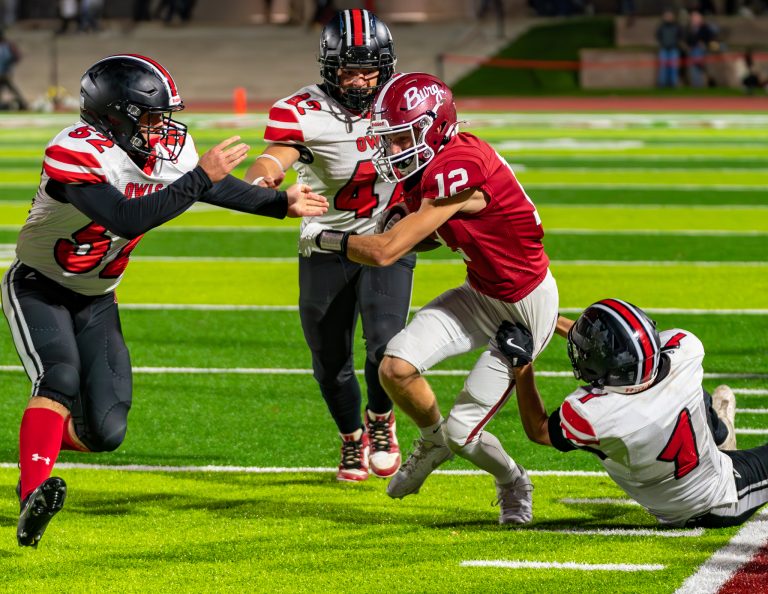 With Owl junior Carter Howery (1) holding on, MHS senior Creighton Byrd (52) and junior Bryson Farr (42) close in to try to get Warrensburg senior Tristan Blew (12) to the ground. (Photo courtesy Tom Boehmer Photography)